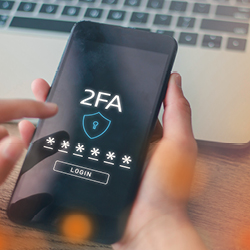 A person holds a smartphone and performs two-factor authentication