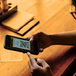 A person scans a QR code on a table at a restaurant