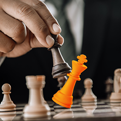 Man&rsquo;s hand capturing a white queen with a black rook on a chessboard