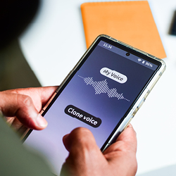 Smartphone in a person&rsquo;s hand showing an app labeled &ldquo;My Voice&rdquo; and &ldquo;Clone voice&rdquo;
